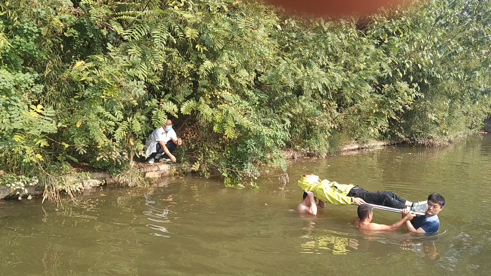 车祸伤者摔落密林水渠旁，民辅警跳入齐胸深水中扛着担架救人｜26℃